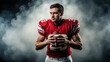© DELstudio - American football player in red uniform holding ball, focused athlete portrait with dramatic smoke background