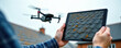 © Viktor - Man in blue plaid shirt controls drone inspecting roof of the house with tablet. Drone hovers in the air above the roof. Tablet displays roof inspection details.