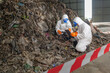 © BESTIMAGE - Environmental Cleanup Team in Full Protective Gear Removing Hazardous Waste from Landfill Site for Environmental Safety and Pollution Control