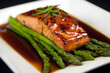 © alfi - Glazed salmon fillet served on a bed of asparagus with soy sauce on a white plate. Food concept