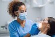© VolumeThings - Female dentist with dark skin treating a patient