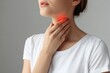 © VolumeThings - Woman self examining thyroid Close up of her neck with a red mark Thyroid issues may involve goiter hyperthyroidism hypothyroidism tumors or cancer Health concern