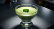 © Rido - Delicious creamy green soup served in a clear glass bowl on a dark glossy surface backdrop