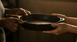 © MiniRiz - Unity in Diversity: A Touching Moment of Connection as Hands Exchange a Cast-Iron Skillet, Symbolizing Sharing and Culinary Heritage in the Kitchen