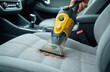 © Maryna - Person using vacuum cleaner removes dirt from car. Detailer cleans vehicle interior upholstery. Car detailing service washes textile from dust and debris.