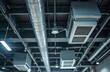 © Pete - Commercial hall ceiling features modern ventilation system. Air conditioning units, metal ducts provide climate control for large spaces. Exposed pipes, cables, lights show building infrastructure,