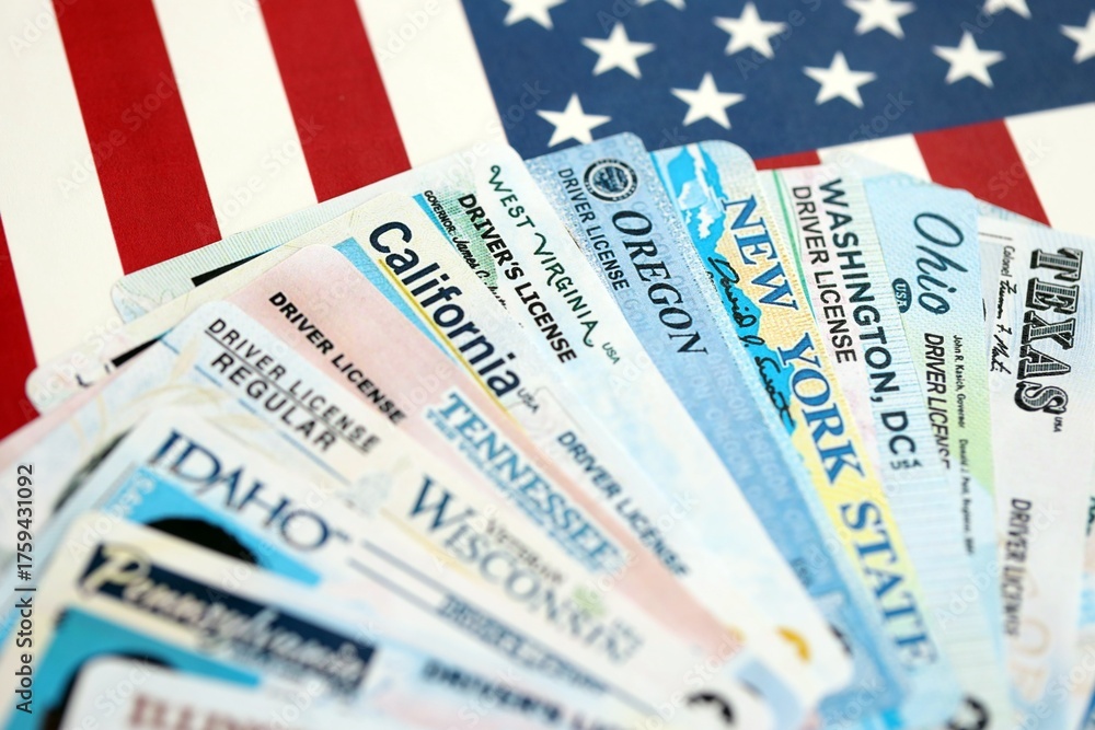 Big amount of driving licenses from different USA states on flag close ...