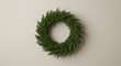 © Zhanna - Green evergreen wreath hanging on beige wall for decoration
