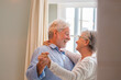 © Daniel - Joyful active old retired romantic couple dancing laughing in living room, happy middle aged wife and elder husband having fun at home, smiling senior family grandparents relaxing bonding together