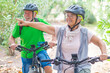 © Daniel - Two happy old mature people enjoying and riding bikes together to be fit and healthy outdoors. Active seniors having fun training in nature. Portrait of one old man smiling in a bike trip with wife