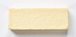 © somsak - A rectangular block of pale yellow cheese with small holes isolated on a white background