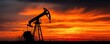 © Tin - Silhouette of oil pump jack against sunset sky concept. Oil pump jack silhouetted against a vibrant sunset sky.