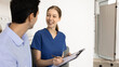 © fizkes - Female nurse asks about health conditions or symptoms to patient