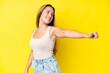 © luismolinero - Young caucasian woman isolated on yellow background giving a thumbs up gesture