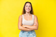 © luismolinero - Young caucasian woman isolated on yellow background keeping the arms crossed in frontal position