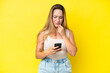© luismolinero - Young caucasian woman isolated on yellow background thinking and sending a message