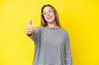 © luismolinero - Young caucasian woman isolated on yellow background with thumbs up because something good has happened