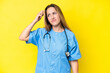 © luismolinero - Young surgeon nurse woman isolated on yellow background having doubts and with confuse face expression