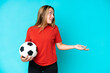 © luismolinero - Young football player woman isolated on blue background with surprise expression while looking side