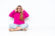 © luismolinero - Young caucasian woman sitting on the floor isolated on white background with surprise expression
