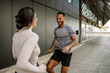 © Drobot Dean - A male athlete laughs while a female athlete is opposite him while they run in place