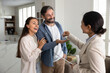 © fizkes - Overjoyed husband wife get keys from apartment from female realtor