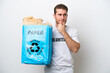 © luismolinero - Young caucasian man holding a recycling bag full of paper to recycle isolated on white background having doubts and thinking