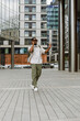 © Drobot Dean - A male worker is walking and smiling while talking on the phone