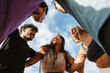 © Drobot Dean - A group of five athletes laugh and hug while standing in a circle