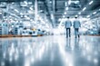 © whitestorm - Blurred workers walking in a modern high-tech industrial factory interior space
