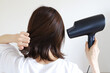 © webbiz - ドライヤーで髪を乾かす女性