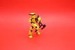© AjiFarid - Yellow Action Figure Holding Dual Axes on Red Background