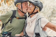 © Daniel - Couple of cute and sweet seniors in love enjoying together nature outdoors having fun with bikes. Old man kissing his wife smiling and feeling good.