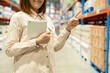 © Patcharanan - Warehouse worker hands holding tablet check stock on tall shelves in warehouse storage. Asian woman auditor or staff work looking up stock taking inventory in cargo store. Owner start up business.