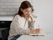© tan4ikk - Happy Girl Doing Homework At Home At The Table