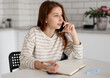 © tan4ikk - Girl Talks On Phone And Writes In Notebook At Home