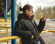 © tan4ikk - Cute Girl With A Phone Waits For A Bus At The Station
