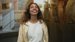 © Krakenimages.com - Woman smiling with face visible and eyes closed amid stone statues in the museum building; quiet joy.