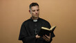 © Krakenimages.com - Priest reading bible man brown background isolated thoughtful spiritual religious faith.
