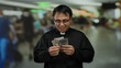 © Krakenimages.com - Priest in airport holding dollars in hands smiling indoors wearing glasses background blurred bright lights busy terminal.