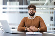 © Liubomir - Young man meditating at his office desk, eyes closed and breathing deeply to relieve stress, promote mindfulness and calm during a busy workday in a modern workspace