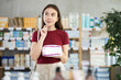 © JackF - In sales area of pharmacy, woman examines packaging of panty liners, reads characteristics and properties. Client check for absence of harmful substances, view product in details