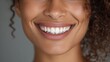 © Johannes - close up face of young woman with beautiful smile isolated on grey wall with copy space successful multiethnic girl latin woman looking at camera against gray wall with a big whitening teeth smile no