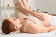 © Pixel-Shot - Beautiful young happy pregnant woman sleeping while having belly massage on couch in spa salon
