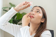 © KMPZZZ - Health care concept, eye problem asian young woman applying, using medical eye drops to treat dry eye and irritation, suffering from irritated eye dry eyes or inflammation, allergy optical symptom.