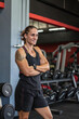 © Everyday Frame - Fit woman with arms crossed in a gym, showcasing her dedication and strength in a healthy lifestyle