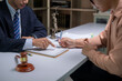© Wasana - A man and a woman are sitting at a desk with a contract in front of them
