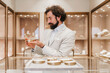 © Dusko - Stylish man looking at an engagement ring in a upscale jewelry store, making a thoughtful decision while shopping for a special gift in a luxury retail environment
