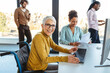 © NDABCREATIVITY - Business woman in wheelchair working with colleague in modern inclusive office. Diversity, support