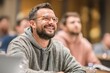 © whitestorm - Happy Bearded Man in Glasses Smiling Attentively During a Modern Workshop